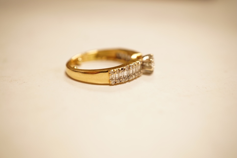 A modern yellow metal and single stone diamond set ring, with baguette and round cut diamond cluster set shoulders, total diamond weight approx. 0.50ct, size J/K (sizing spheres), gross weight 4.6 grams.